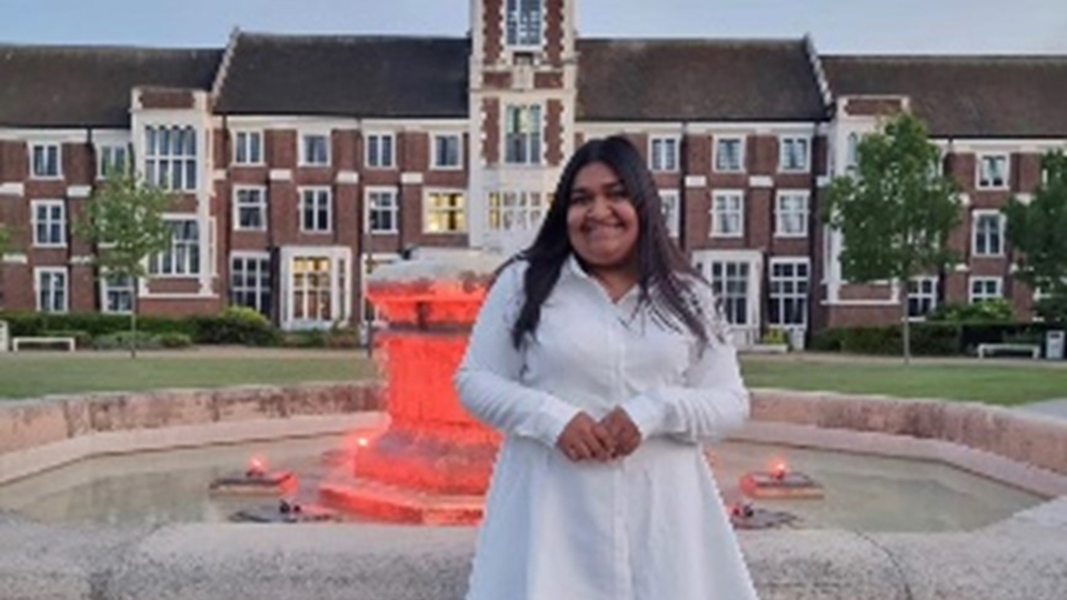 A student standing in from of a fountain