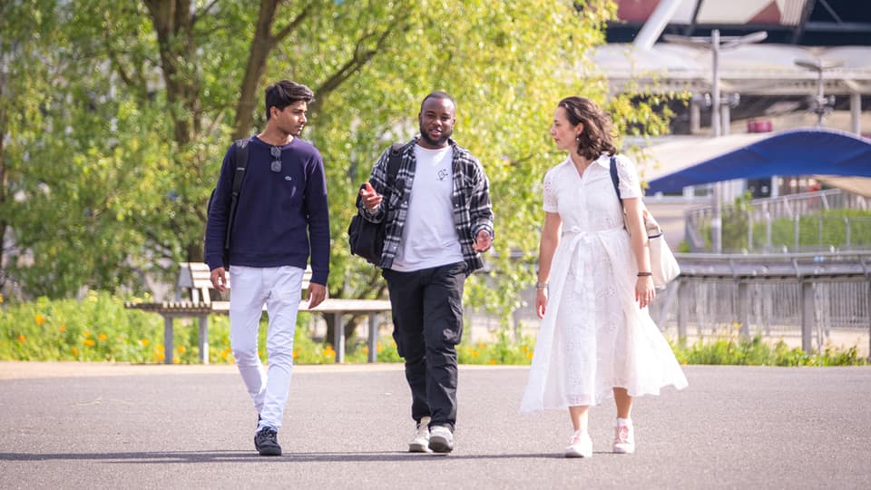 Three postgraduate students walking through London campus