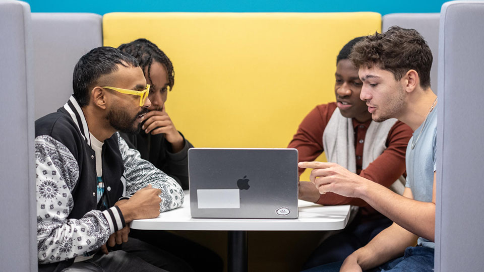 A group of students sitting at a table and having a discussion