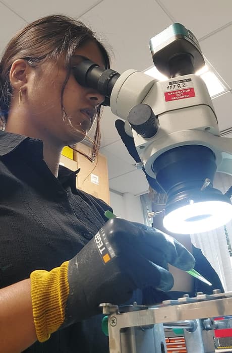 Nikitha microsoldering electronic components using specialist engineering equipment during her internship.