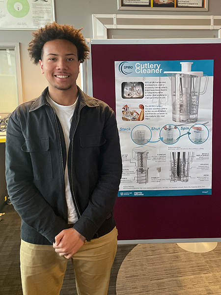 Thomas displaying his project poster.