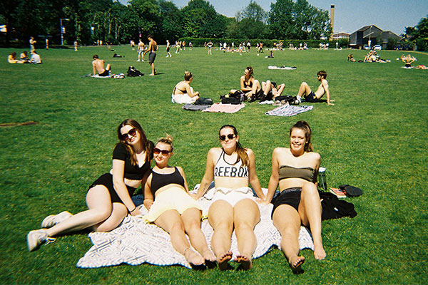 A group of female students relaxing on the grass during a sunny afternoon