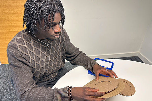Experimenting with a cardboard prototype of my design