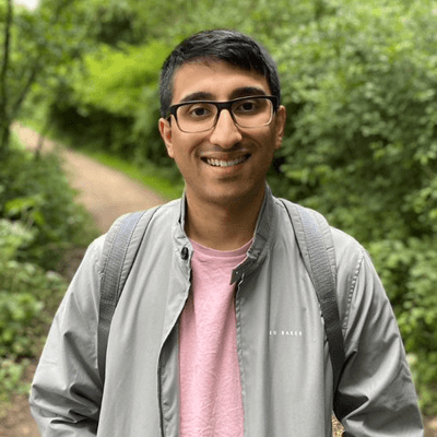 Male student standing outside in front of greenery