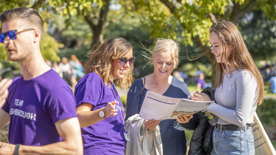 Staff giving open day visitors directions.