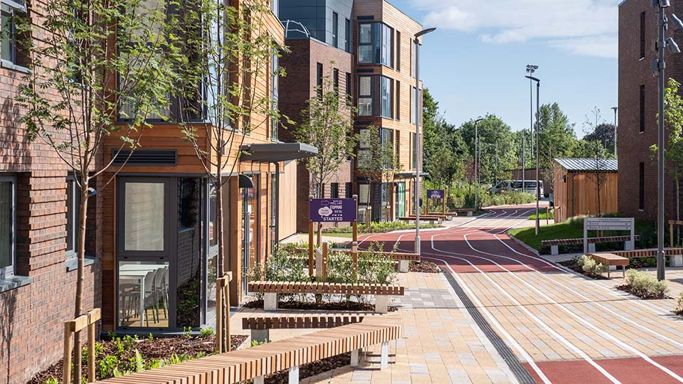 Modern student accommodation buildings with landscaped walkways and seating areas