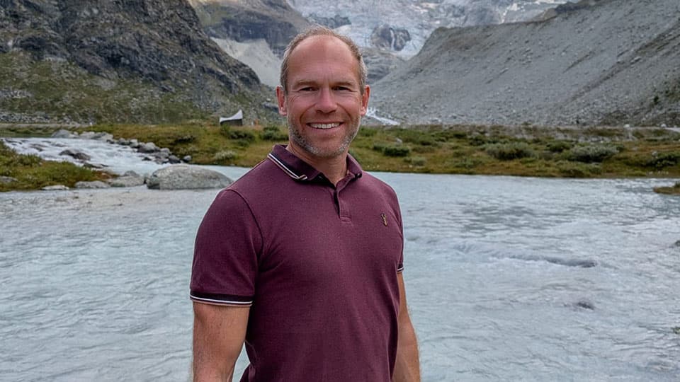 Peter Kraftl in a landscape with mountains and a river