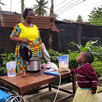 a woman and child cooking outside