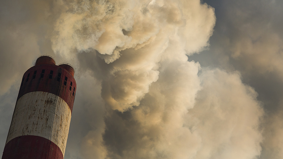 A chimmney releasing smoke into the air. 