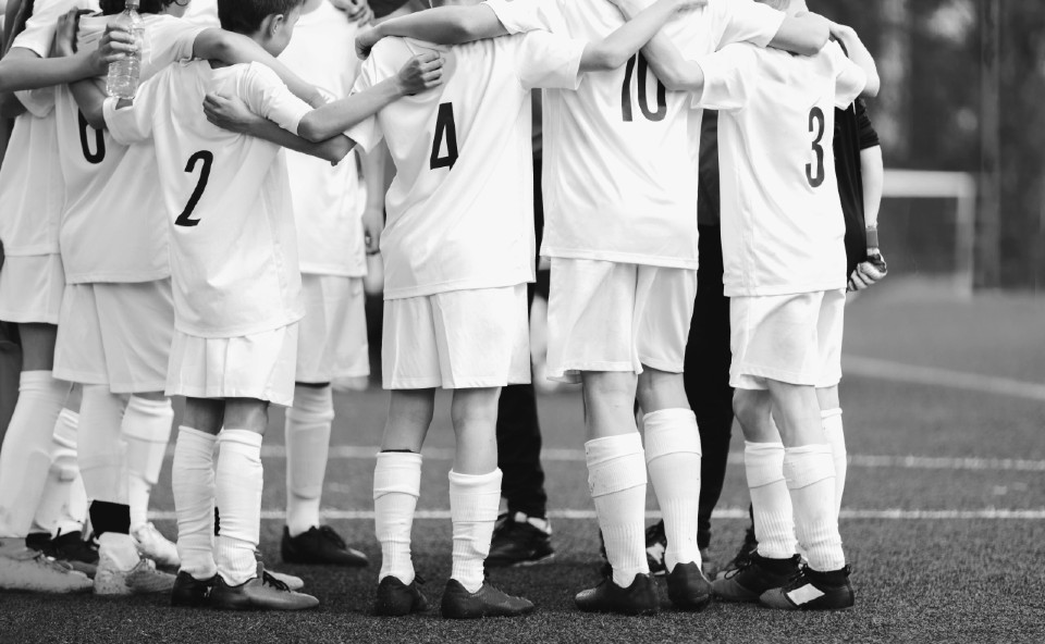 Child football team huddling 