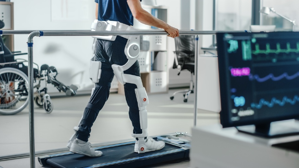 Man on a treadmill with an exoskeleton leg support 