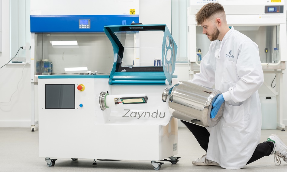 A researcher from Loughborough agritech spinout Zayndu, stood with the company's world-first ‘activated air’ seed processing system