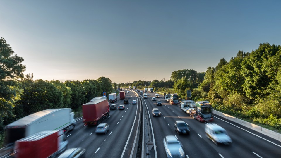 Image of a UK motorway with cars and lorries on it, there is a slight blur on the image.