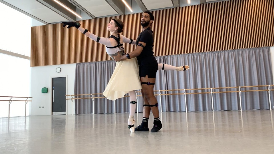 Two ballerinas dancing with sensors on their limbs and heads