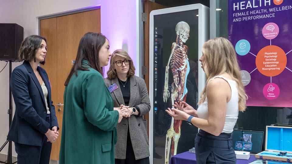 Four people networking at an event on campus.