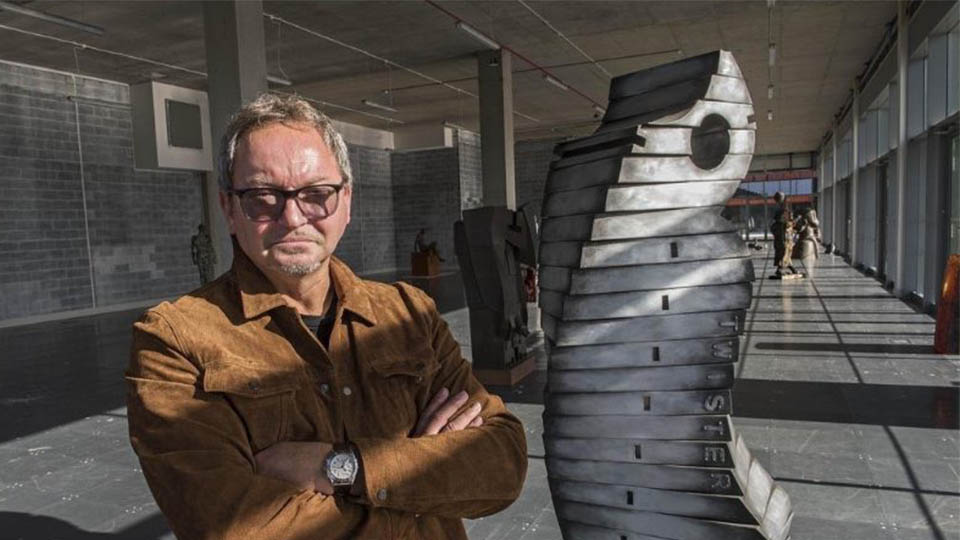 John Atkin standing with Twister sculpture