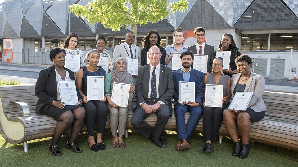 photo of VC Bob sat with graduating students of the Inspiring Success programme at the LUL campus