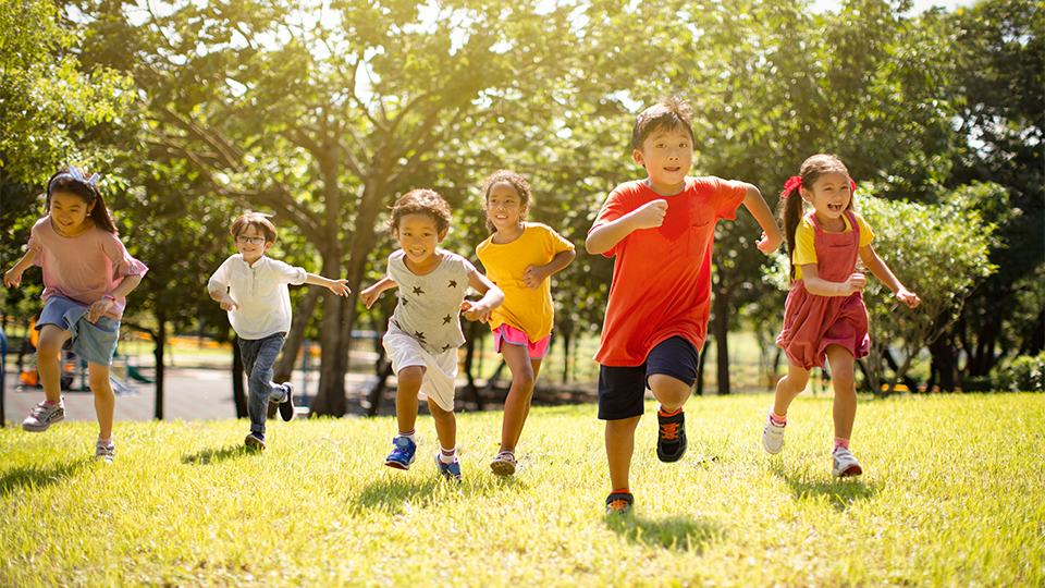 A group of young children running outside