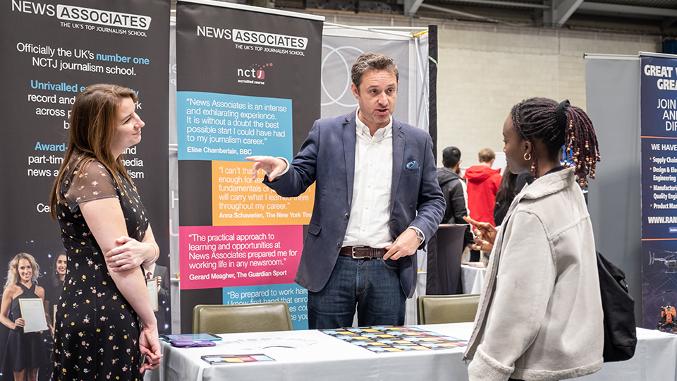 Photo of employers talking to students at stand at Careers Fair 2021