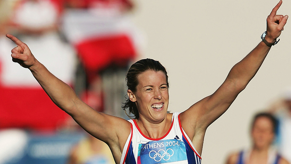 Picture of Georgina Harland with hands raised in the air, in excitement.