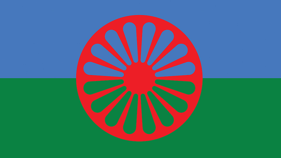 Blue and green striped flag with a red Chakra in the centre, the official emblem of the Roma