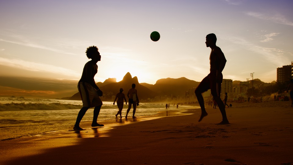 footballers playing on a beach in brazil