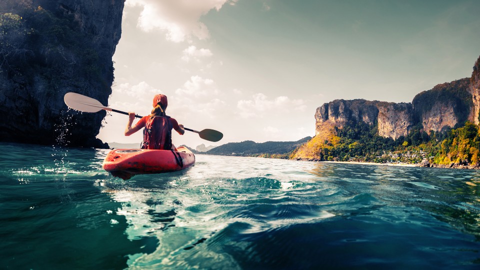 a woman kayaks a river 