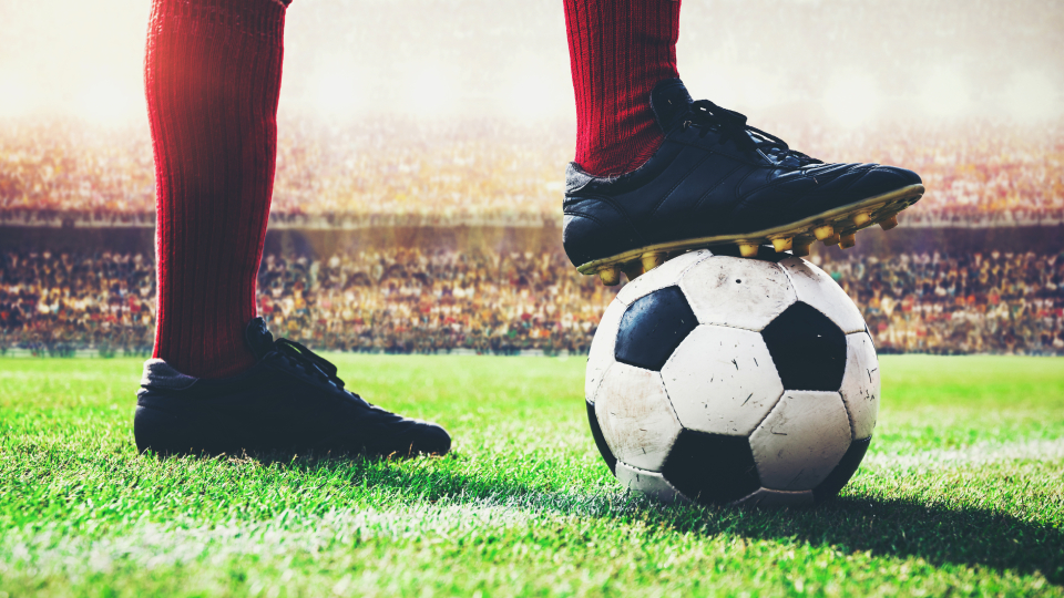 a close-up of a football with a player trapping the ball