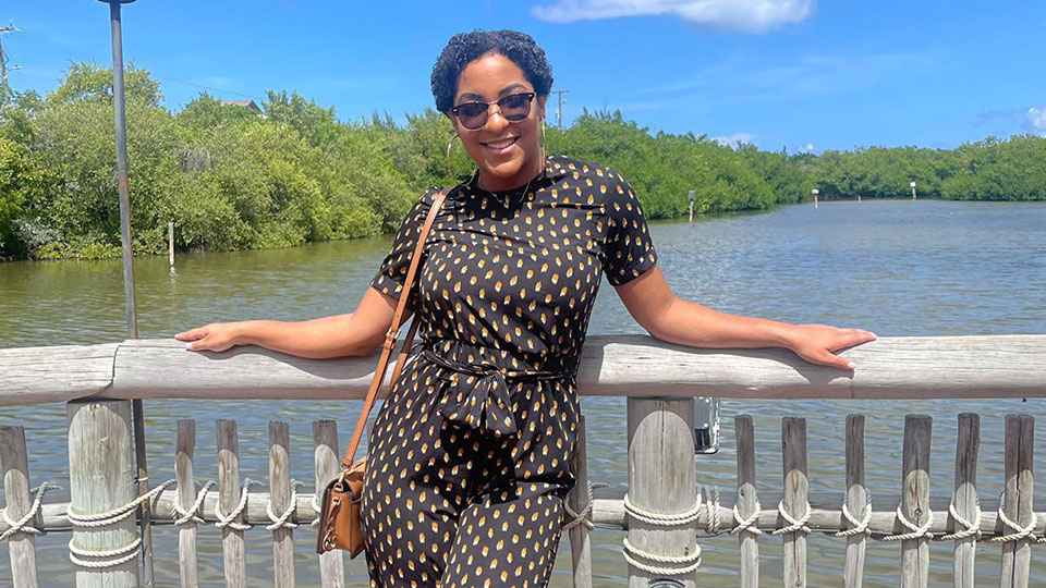 Women in black spotted jumpsuit standing on a bridge