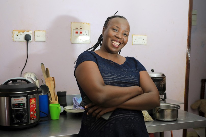 Woman in a kitchen standing next to an electric cooker