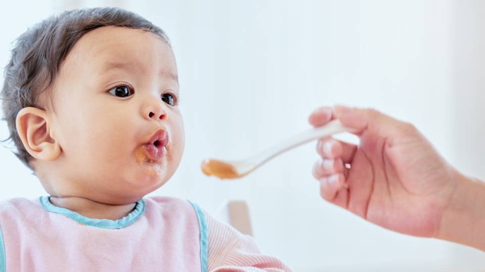 a baby eating baby food
