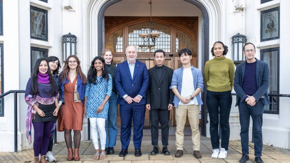 Group of students standing with Professor Nick Jennings in front of Hazlerigg Building.