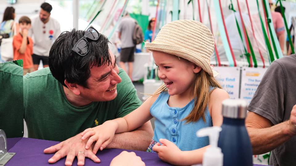 A man and girl take part in a festival exhibit in the Discover Zone