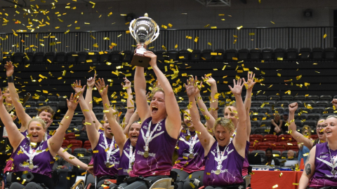 lightning wheelchair basketball players lift a trophy