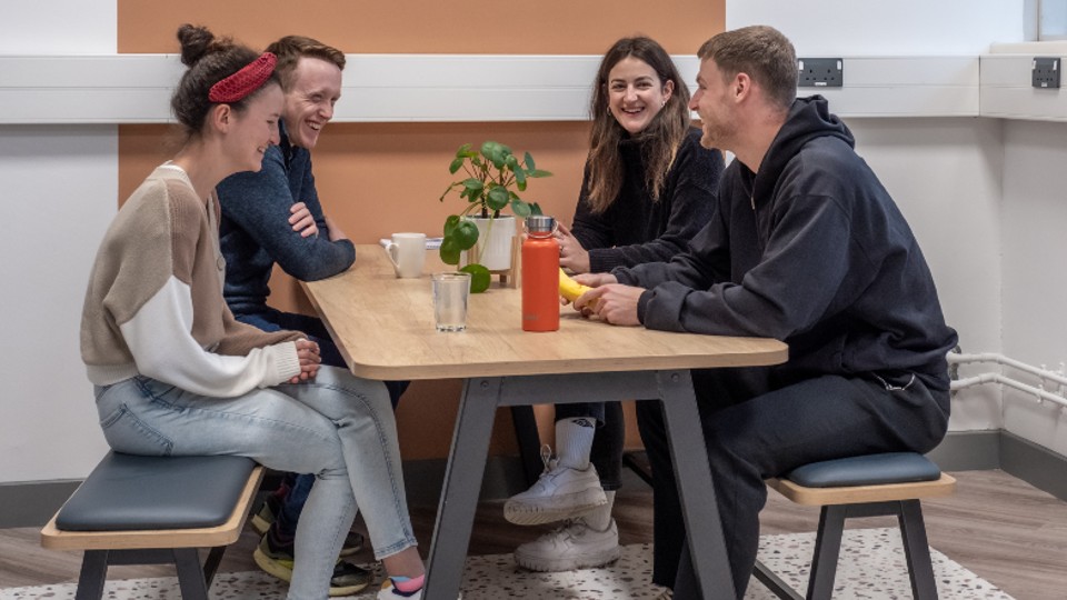 A group of students sitting at a table in the University's business incubator