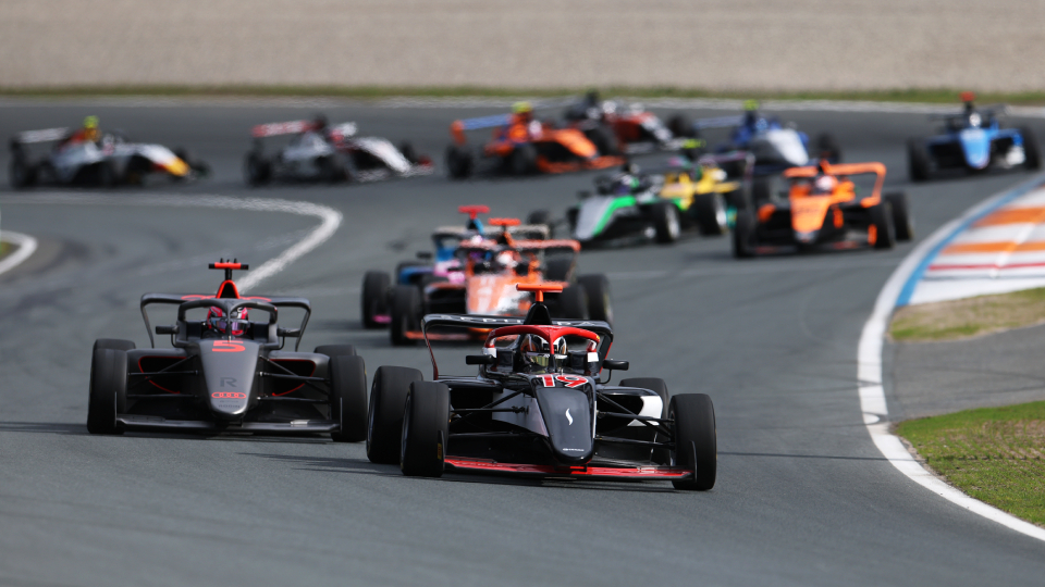 f1 cars driving around a track