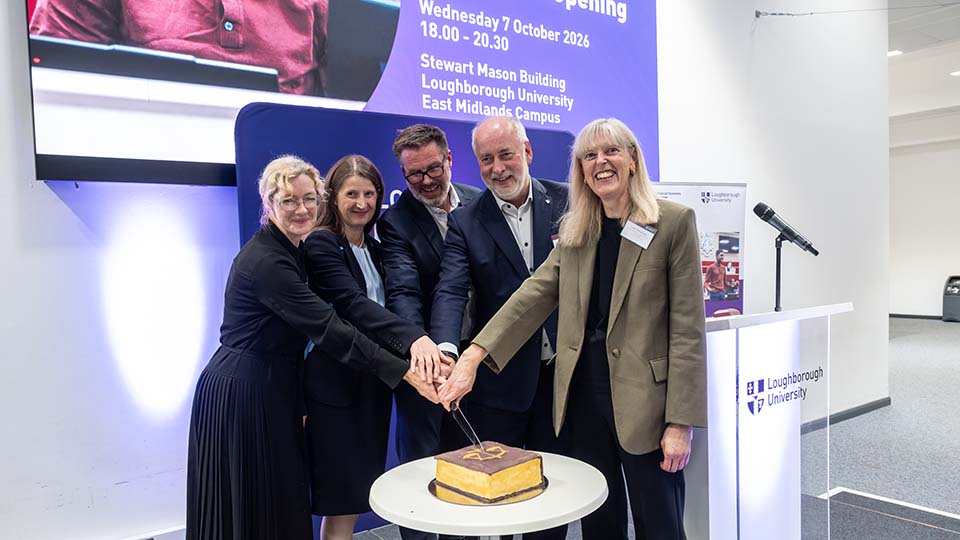 Five members of staff cutting a cake shaped like a volume of law reports