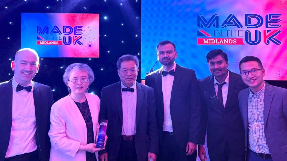 Six people standing together at the Made in the Midlands Awards ceremony holding a trophy.