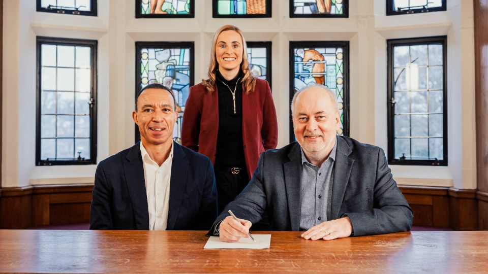 three people sat behind a desk