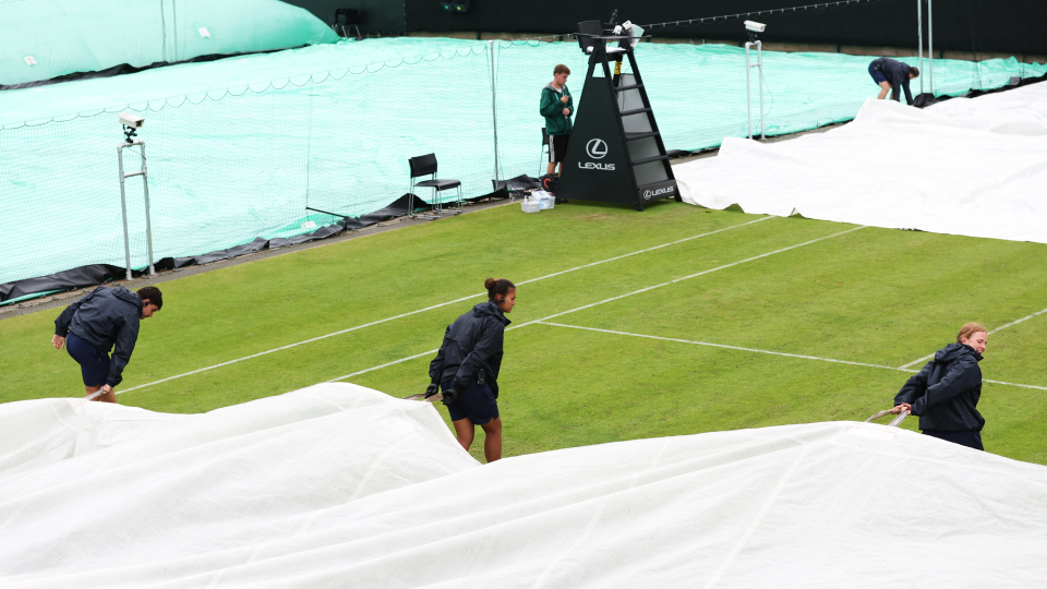 covers being pulled onto a tennis court