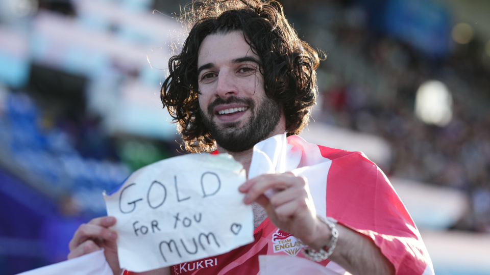 Zac Shaw holds a message for his late mum after winning gold in the Men's 100m T12.
