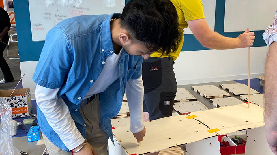 Male student in an architecture studio looking at a small-scale architectural model.