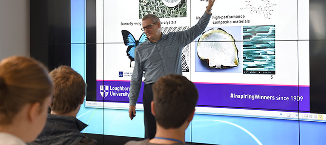 a lecturer standing in front of a projected presentation