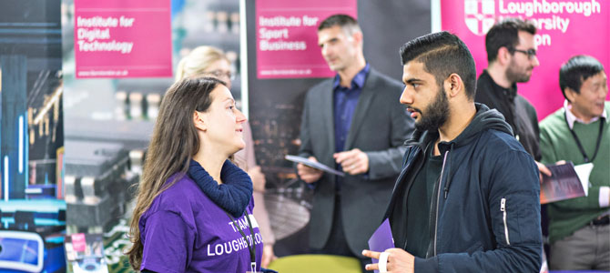 Student at an open day talking to a staff member in a Team Loughborough t-shirt