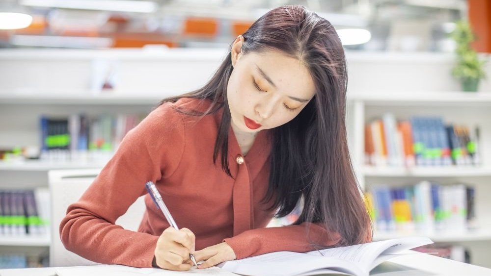 A photo of a student studying with books