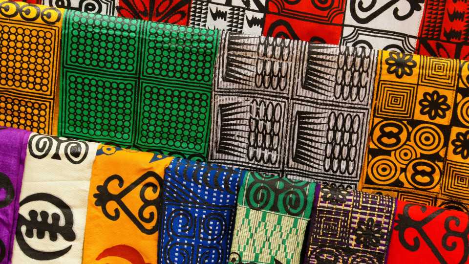 A collection of printed fabrics in various bright colours with detailed patterns.