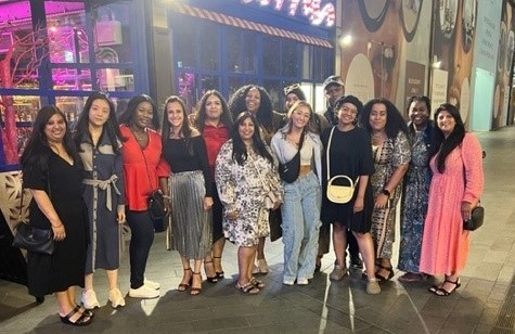 Photo of a group of staff and Doctoral Researchers part of the BAME Staff Network stood outside a restaurant at night time smiling towards the camera
