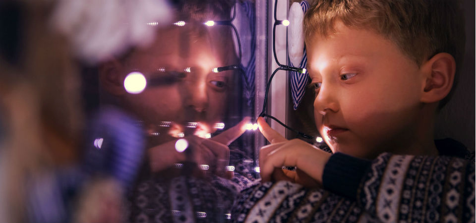 photo of a young boy looking at Christmas lights