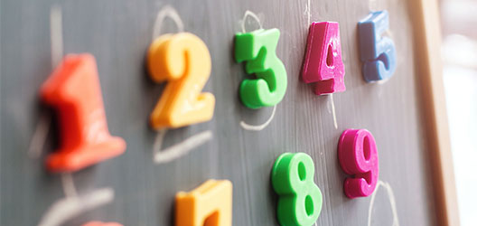 Different coloured numbers stuck on a board used to teach children about numbers
