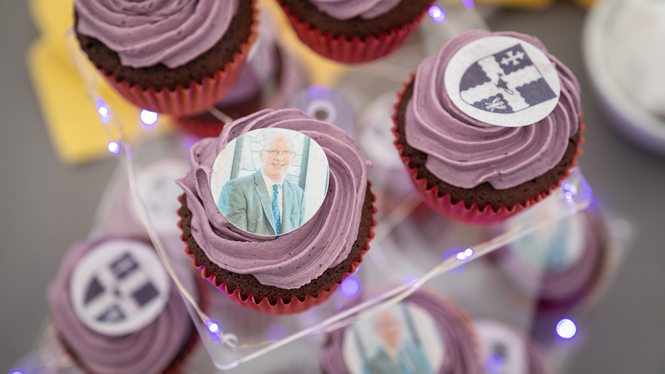 Photo of purple iced cupcakes with the University logo or a photo of Professor Robert Allison